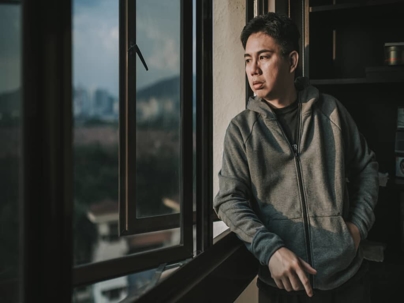 a worried man looking out a window